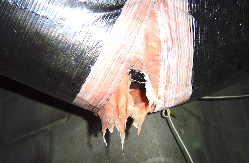 Duct insulation and jacket blown out by the collection of water that dripped into the duct insulation from an uninsulated boot