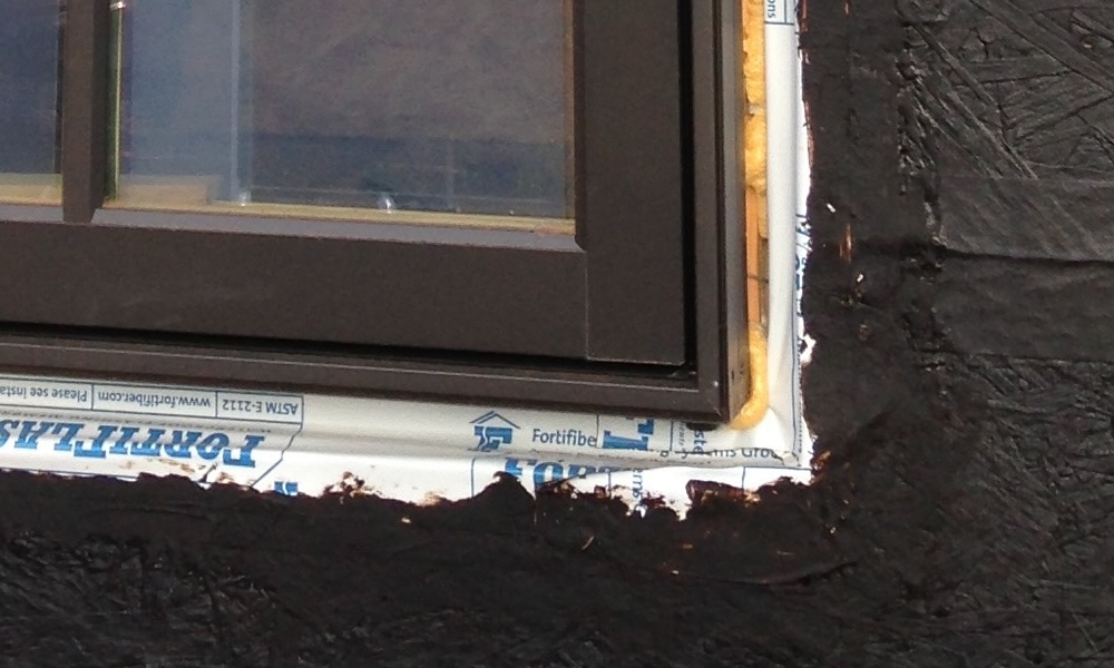 Window sill flashing with tape and liquid-applied membrane